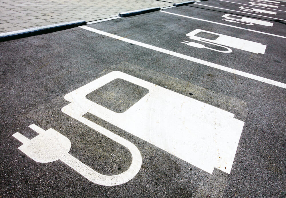 Empty parking spaces in a commercial lot with marked EV charging spots.